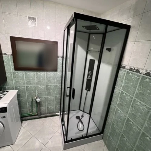 Łazienka z czarną kabiną prysznicową i pralką — DobryHydraulik Szczecin